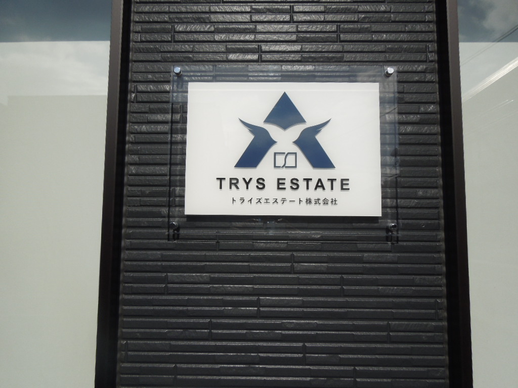 事務所に掲示されたTRYS ESTATEの看板